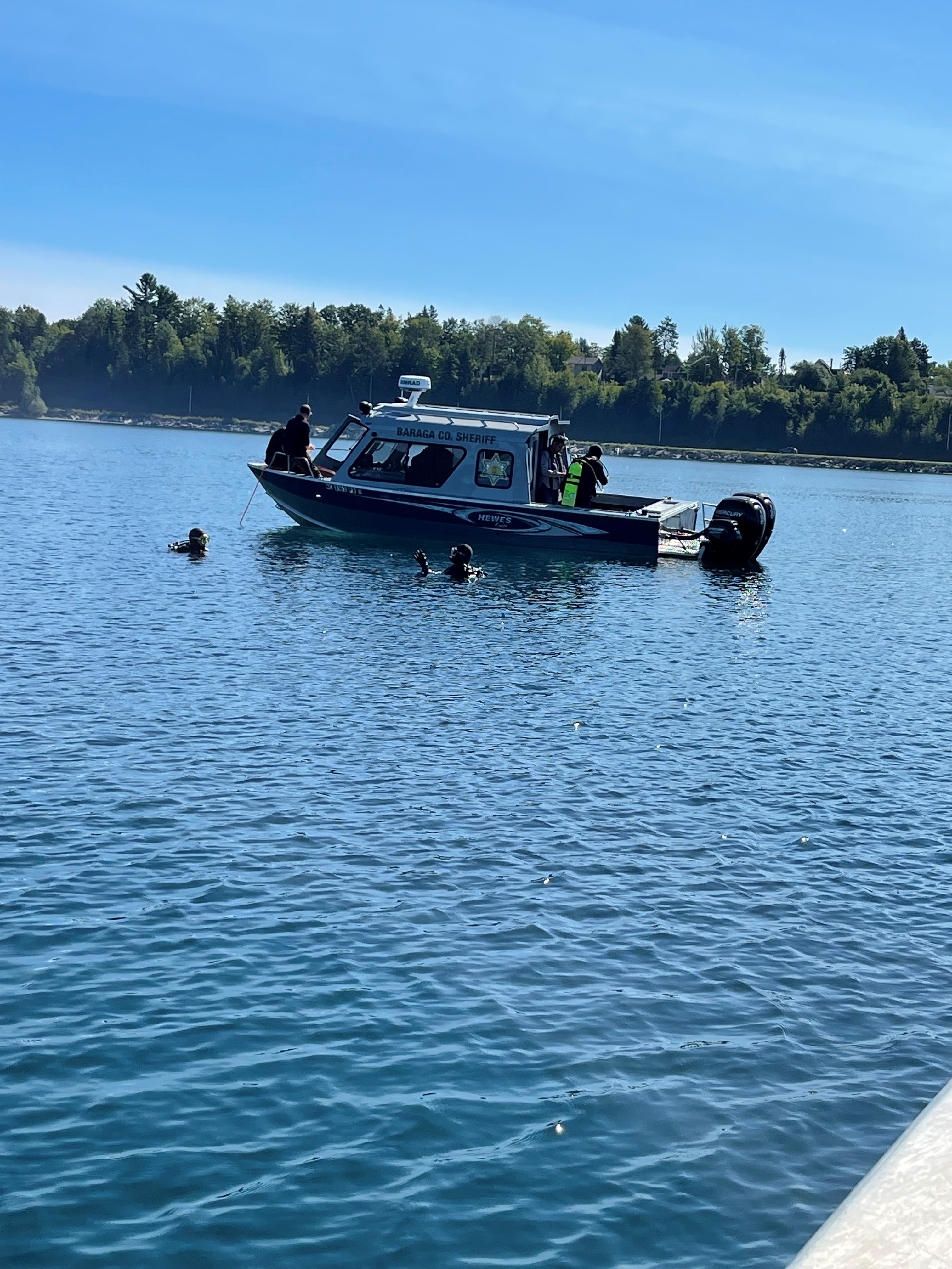 Divers and volunteers in the water around a boat removing marine debris.